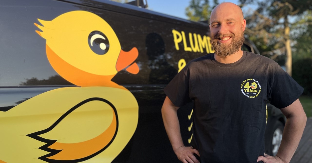 Plumbing and Heating Gas Engineer Alex stood smiling next to his Yellow Duck van